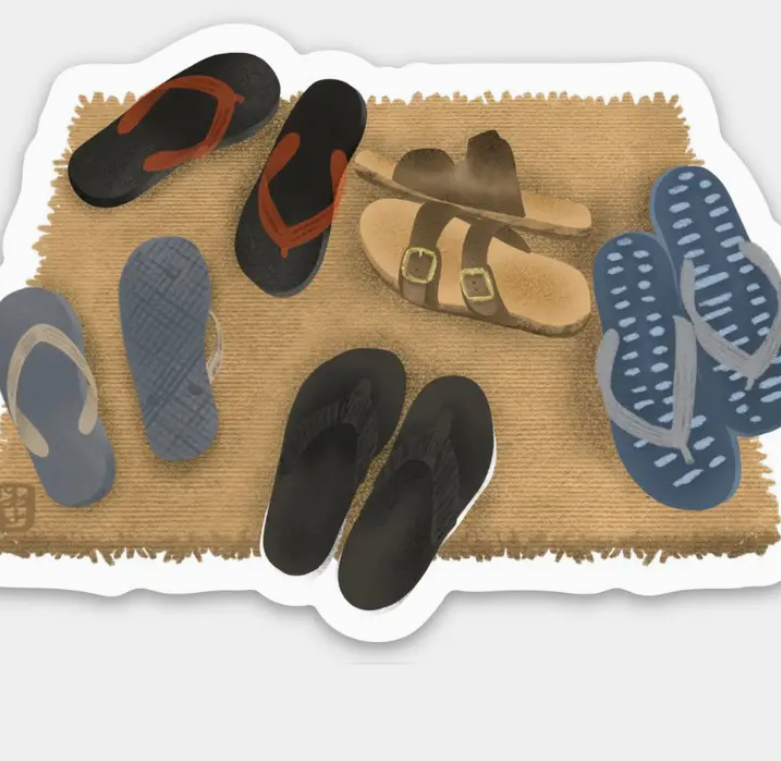 Doormat with various pairs of sandals and flip-flops on a textured surface