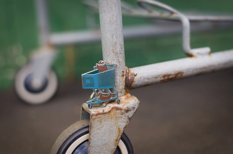 Small blue toy shopping cart on a rusted metal surface with blurred background