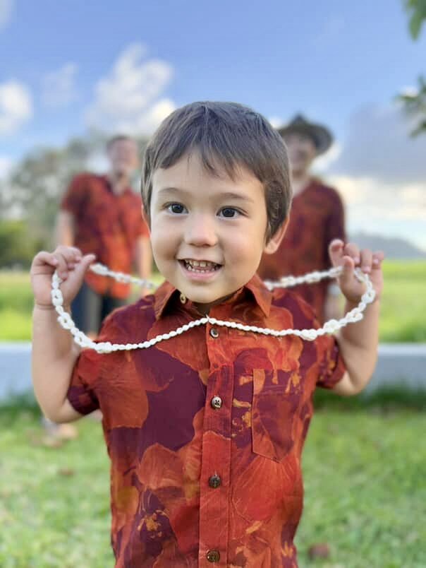 Boys red floral pattern aloha shirt on a red background