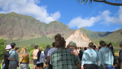 Group of people gathered outdoors with mountains in the background